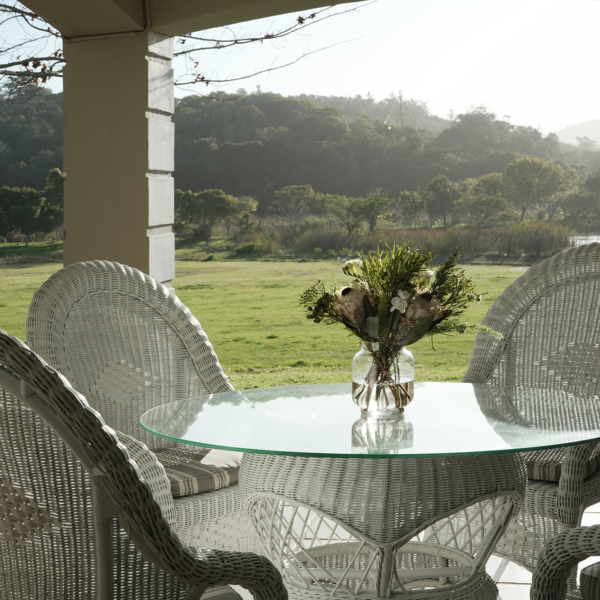 wicker chairs and table on a patio overlooking the grounds at Kwendalo Wellness Centre